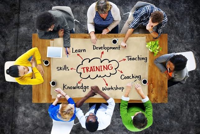 Seen from above, a group works around a table on a training plan