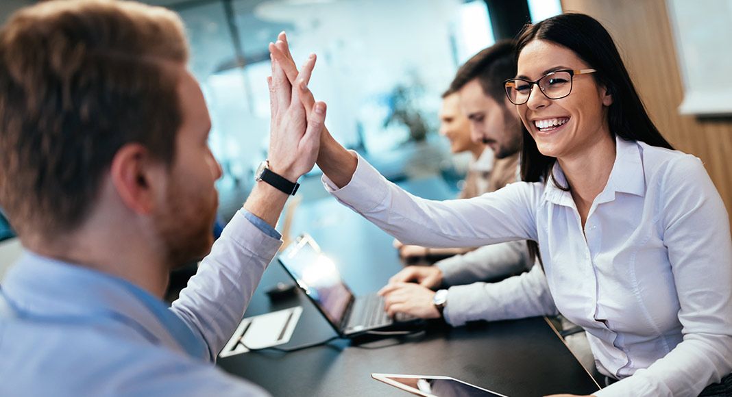 Two colleagues high-five after a win