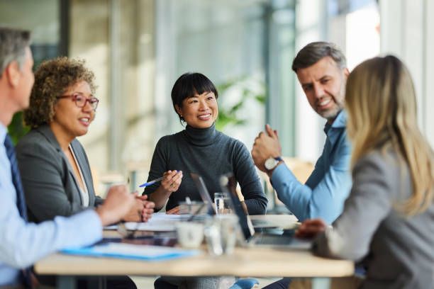 A smiling team meets around a table